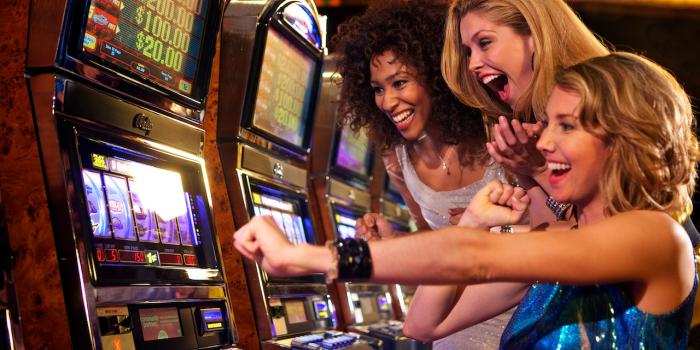 3 females playing a slot machine
